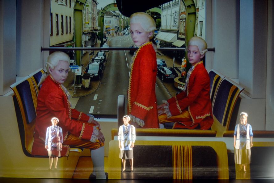 Oper Wuppertal / Die Zauberflöte - hier : Die 3 Knaben auf der Bühne und gleichzeitig Schwebebahn fahrend © Jens Grossmann