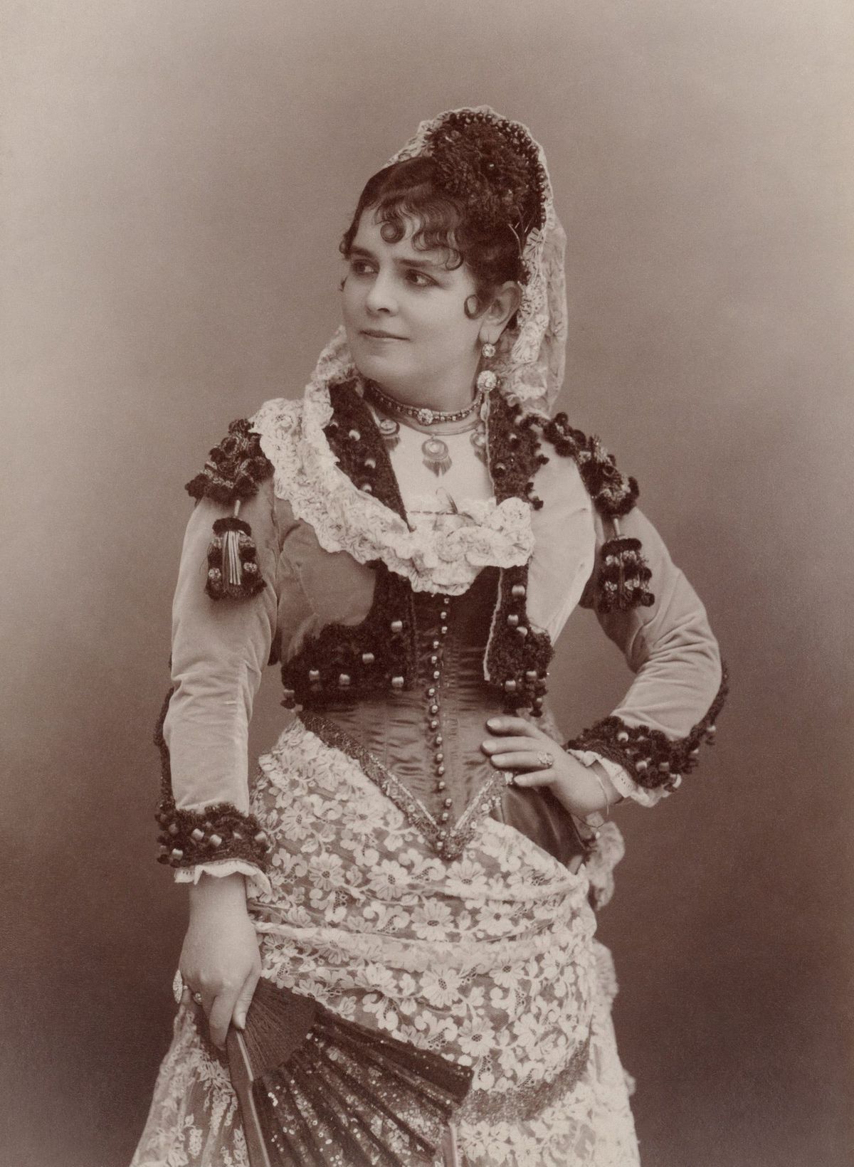 Historische Fotografie: Die Sängerin Célestine Galli-Marié im spanischen Kostüm der Carmen mit Spitzenschleier und Fächer