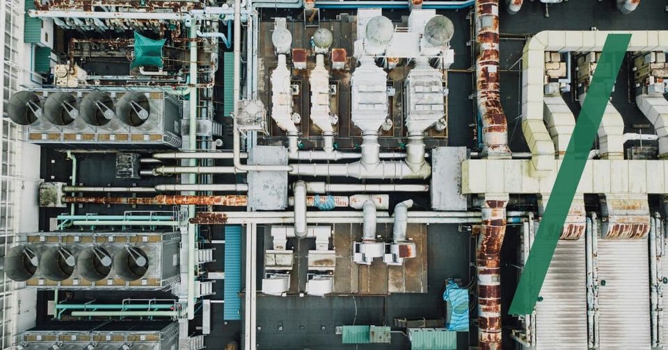 Foto: Luftaufnahme einer Industrieanlage mit Rohrleitungen und Kühltürmen. CHUTTERSNAP/Unsplash