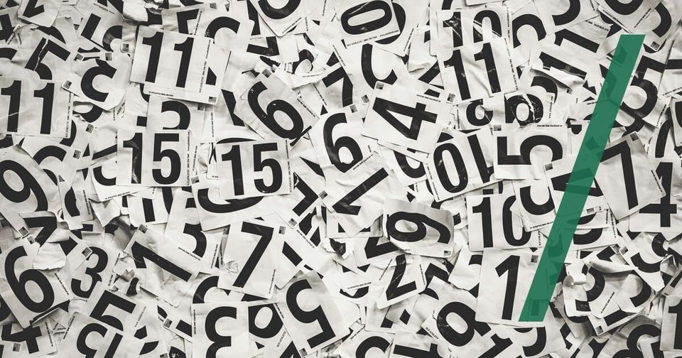 Foto: Ein Haufen ausgeschnittener Papierziffern in Schwarzweiß. Cooper Hofmann/Unsplash