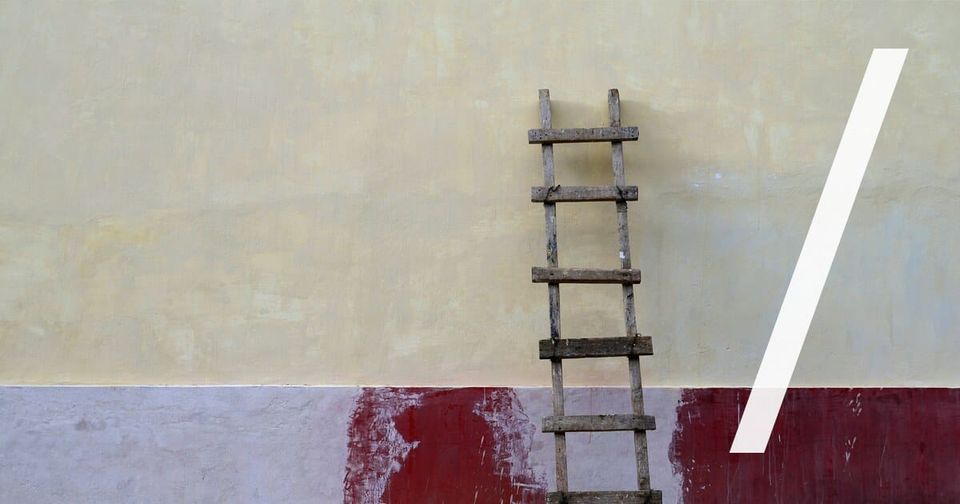 Foto: Eine Holzleiter lehnt an einer verputzten Wand, alle Sprossen sind sichtbar. Max Böhme/Unsplash
