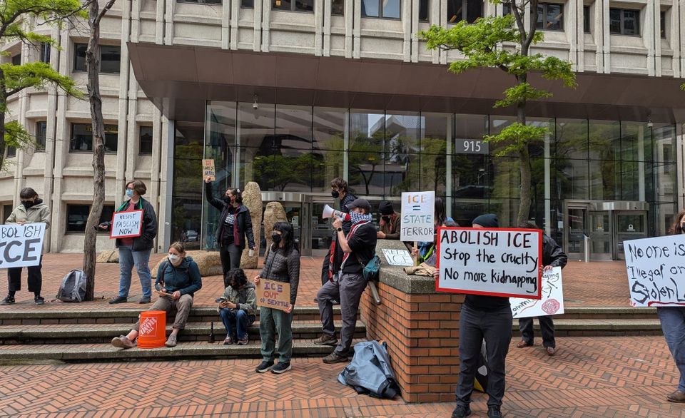 people gather with signs outsidwe building