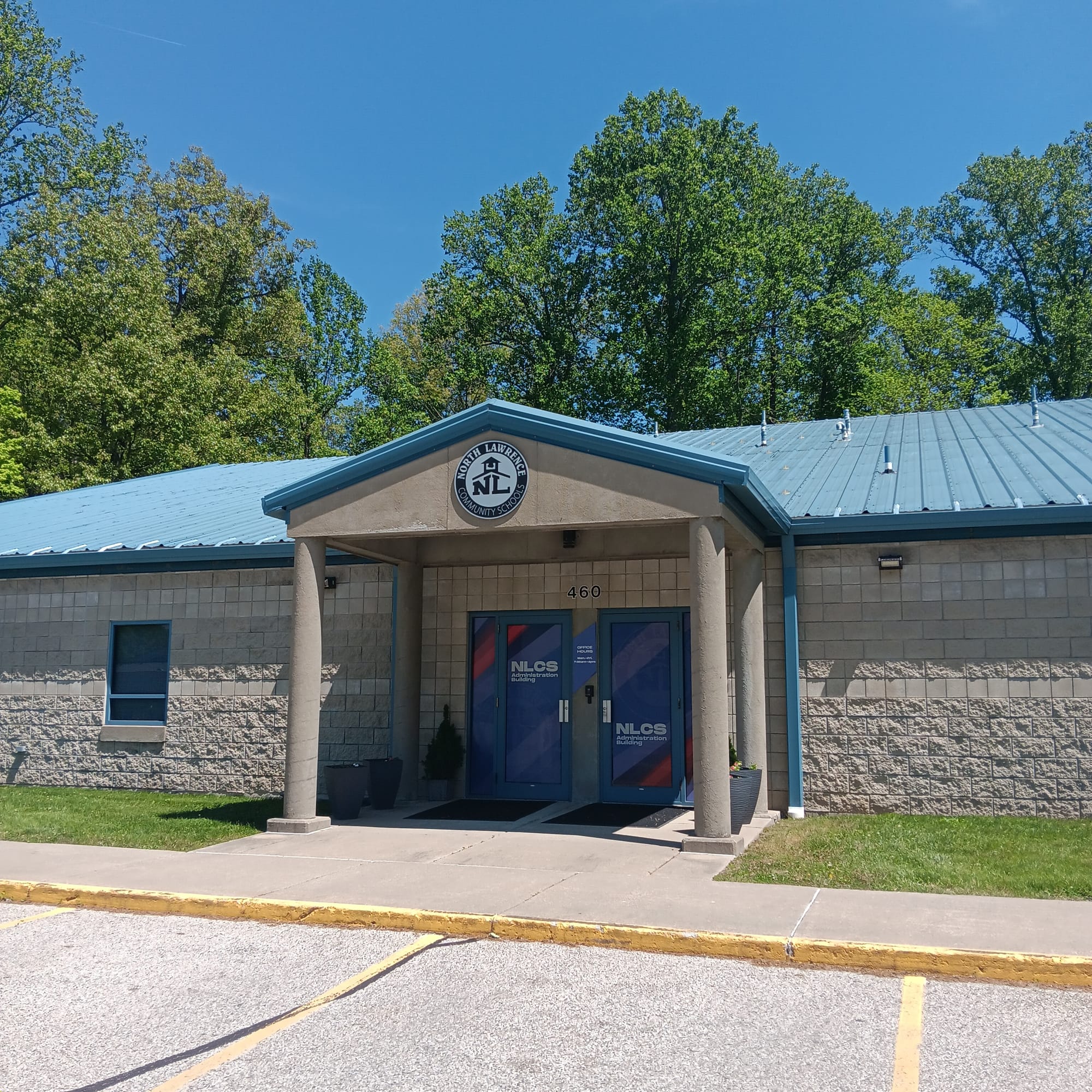 the NLCS administrative office is a concrete building with a blue corrugated steel roof