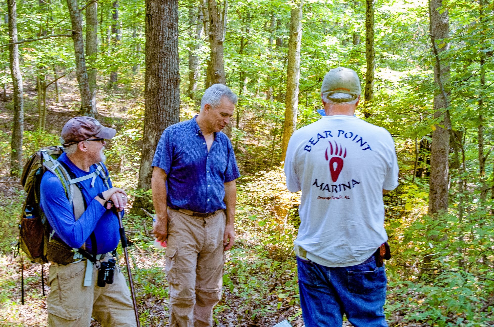 three men talking in the forest