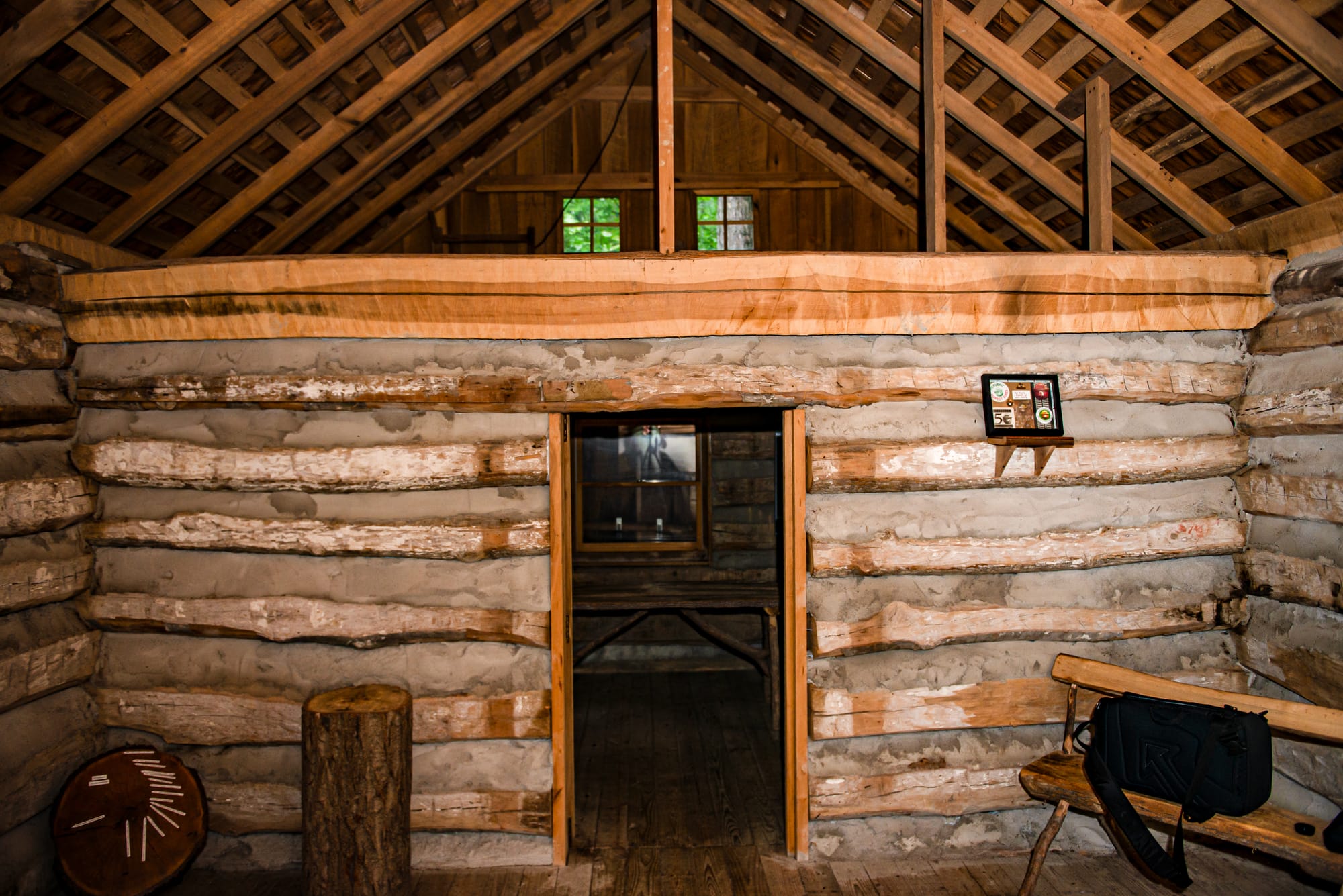 the interior of a log cabin with clay mortar between the log beam walls
