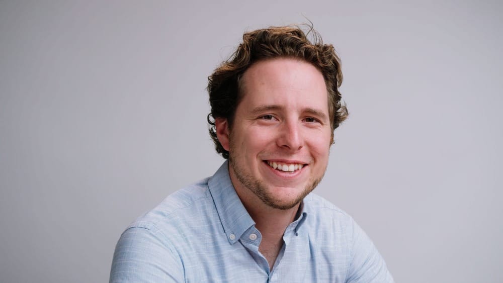 a blond-haired man in a blue button-down shirt
