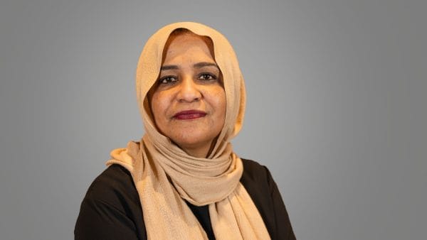 headshot of a woman wearing a black burka and light brown hijab