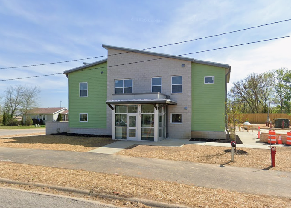 new construction of a two-story mint green building with a stone facade entrance