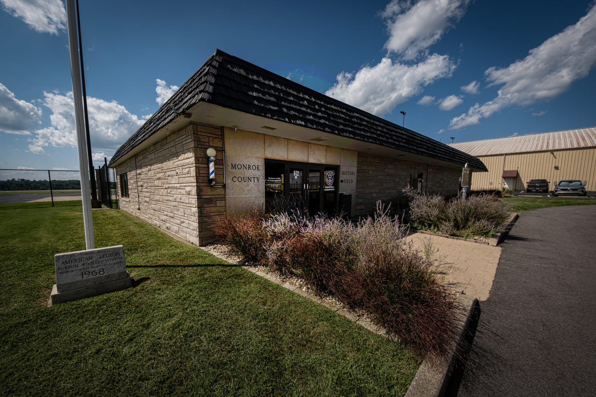 a one story limestone building with a flat black roof. Signage reads MONROE COUNTY KISTERS FIELD