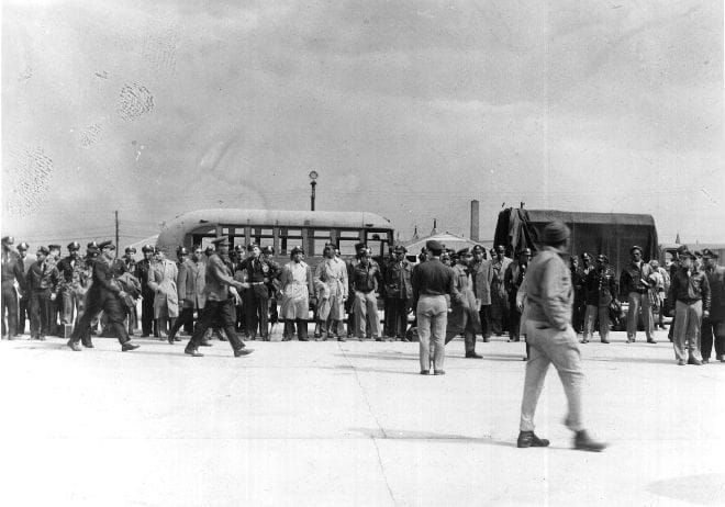 a black and white photograph of a line of African-American Air Force officers under arrest