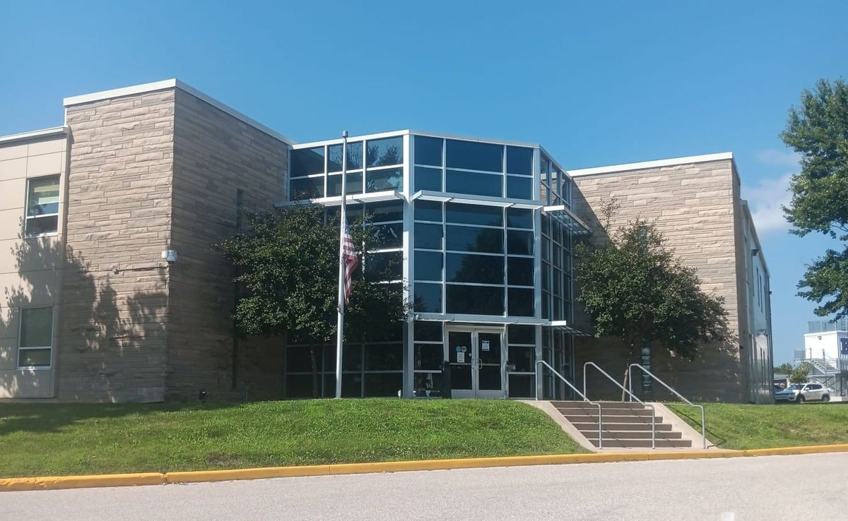 A limestone building with a tall steel and glass entrance