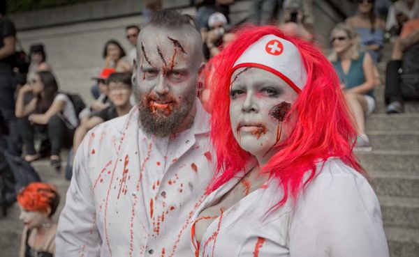 A man and a woman dressed as zombies in doctor and nurse outfits.