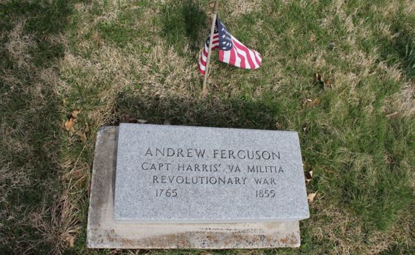 a rectangular grave mark with words ANDREW FERGUSON CAPT HARRIS' VA MILITIA REVOLUTIONARY WAR 1765 1855. A small American flag is stuck in the grass beside the grave