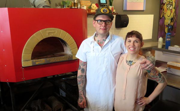 Adam (left) and Alicia Sweet, owners of King Dough pizza, stand next to their Italian brick oven in their brick-and-mortar lo