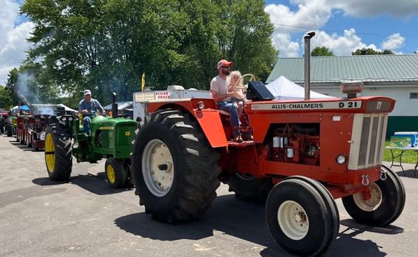 Three generations of tractor enthusiasts ride in the parade at the Monroe County Antique Machinery Association Show in May. E