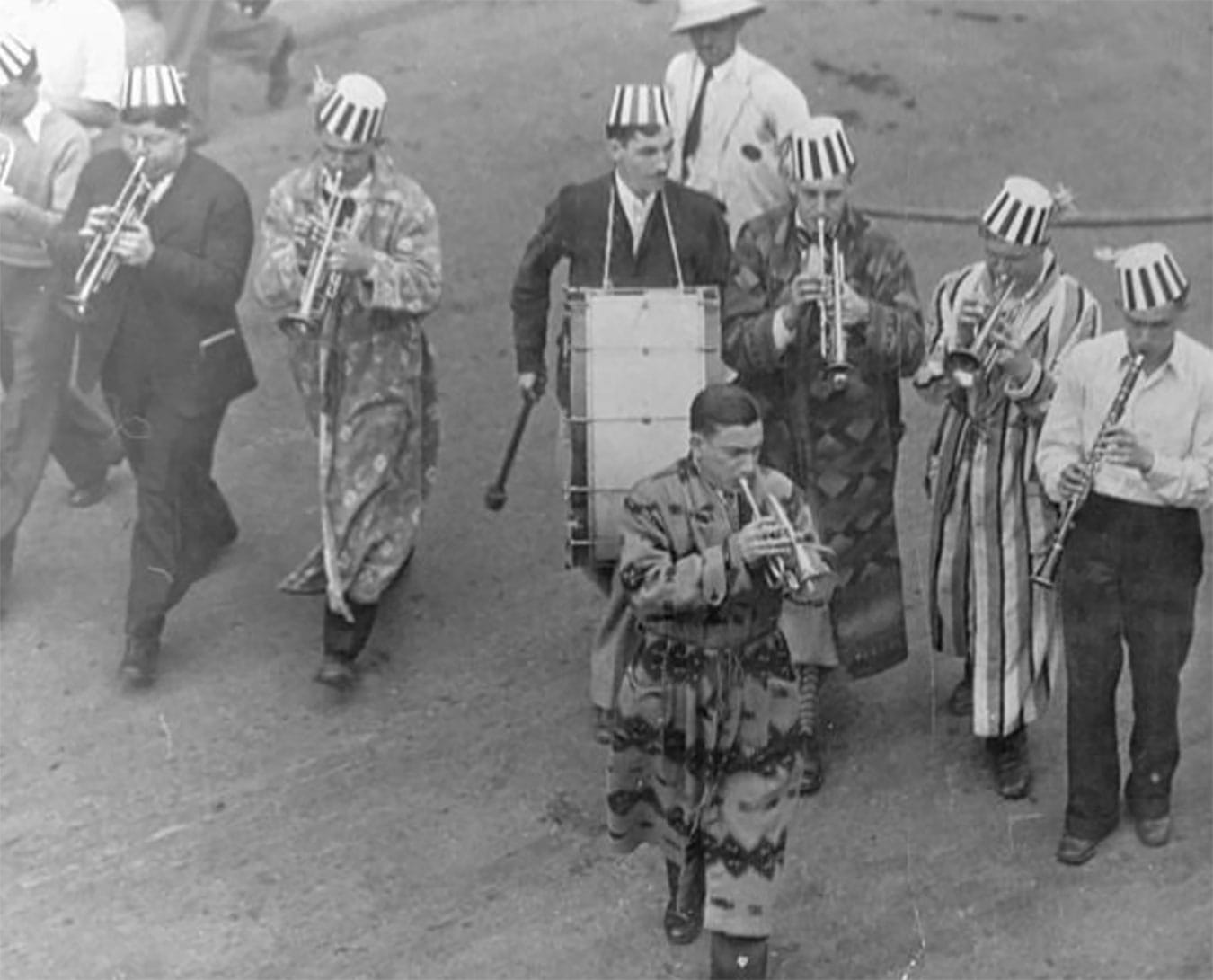 Carmichael (front, with cornet) leads the parade to a mock 
