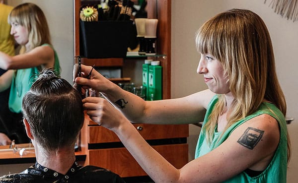 Cathleen Paquet, a hairstylist at Hairstream Studio, styles a client's hair. She says this trade allows her "to connect with other people really deeply." This photo was taken for Jenny Elig's story "Hair Apparent: Stylists Give More Than Good Looks." | Photo by Mark Anthony Kathurima
