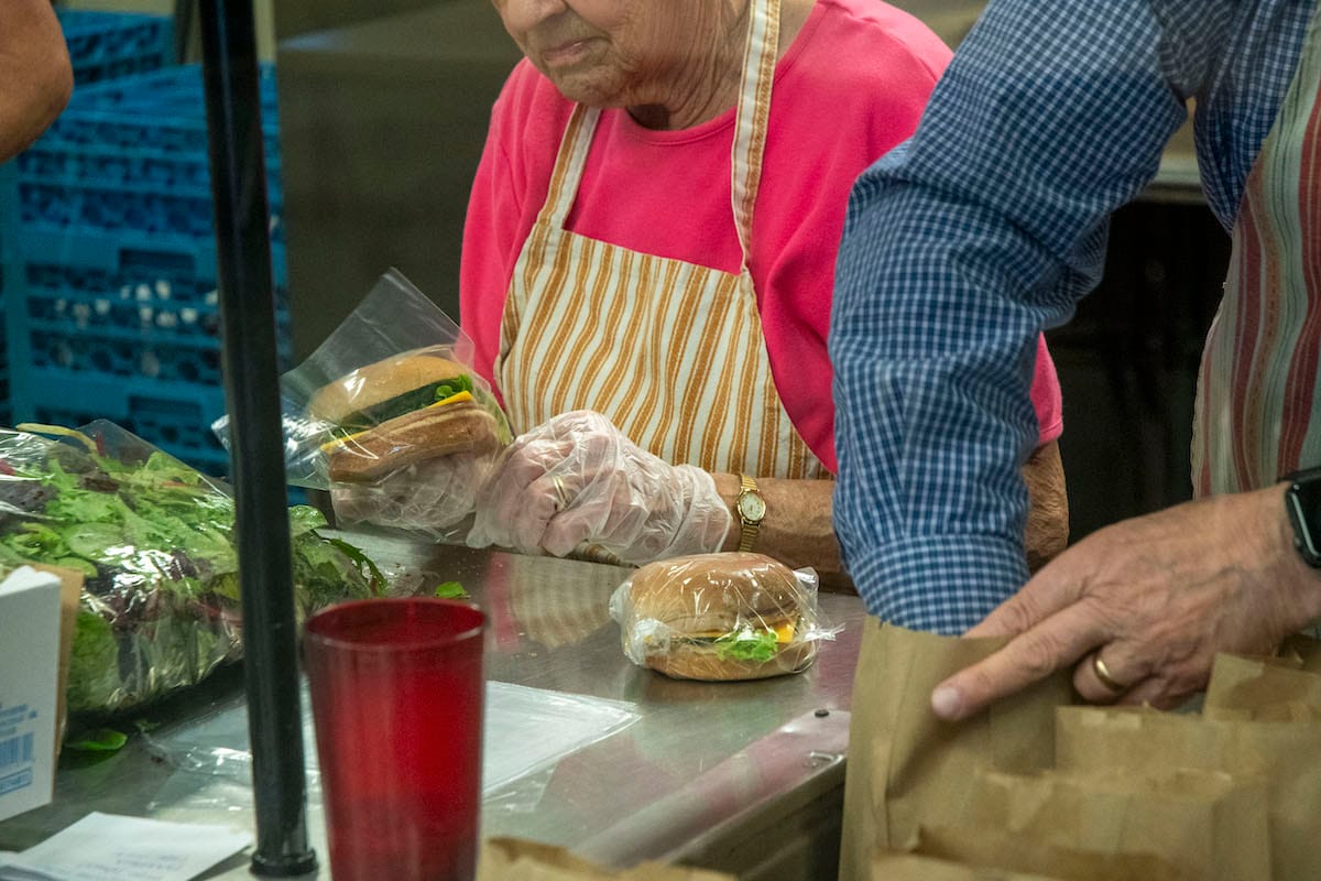 Volunteers at Community Kitchen of Monroe County wrap sandwiches and prepare sack lunches for at-risk children in Bloomington. | Photo by Olivia Bianco