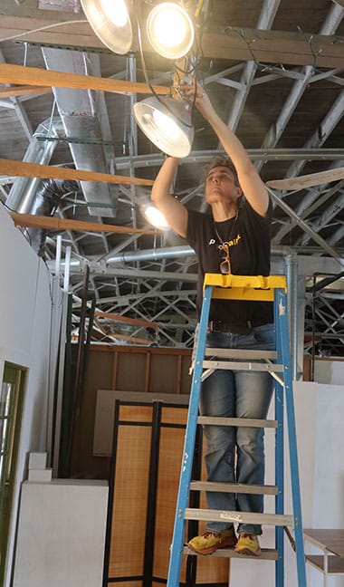 Cooper Pennington adjusting the lighting for her exhibition in the I Fell Gallery. | Photo by Claude Cookman