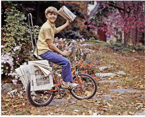 A boy delivers newspapers on his bike in 1974. | Photo by Media/ClassicStock/Getty Images