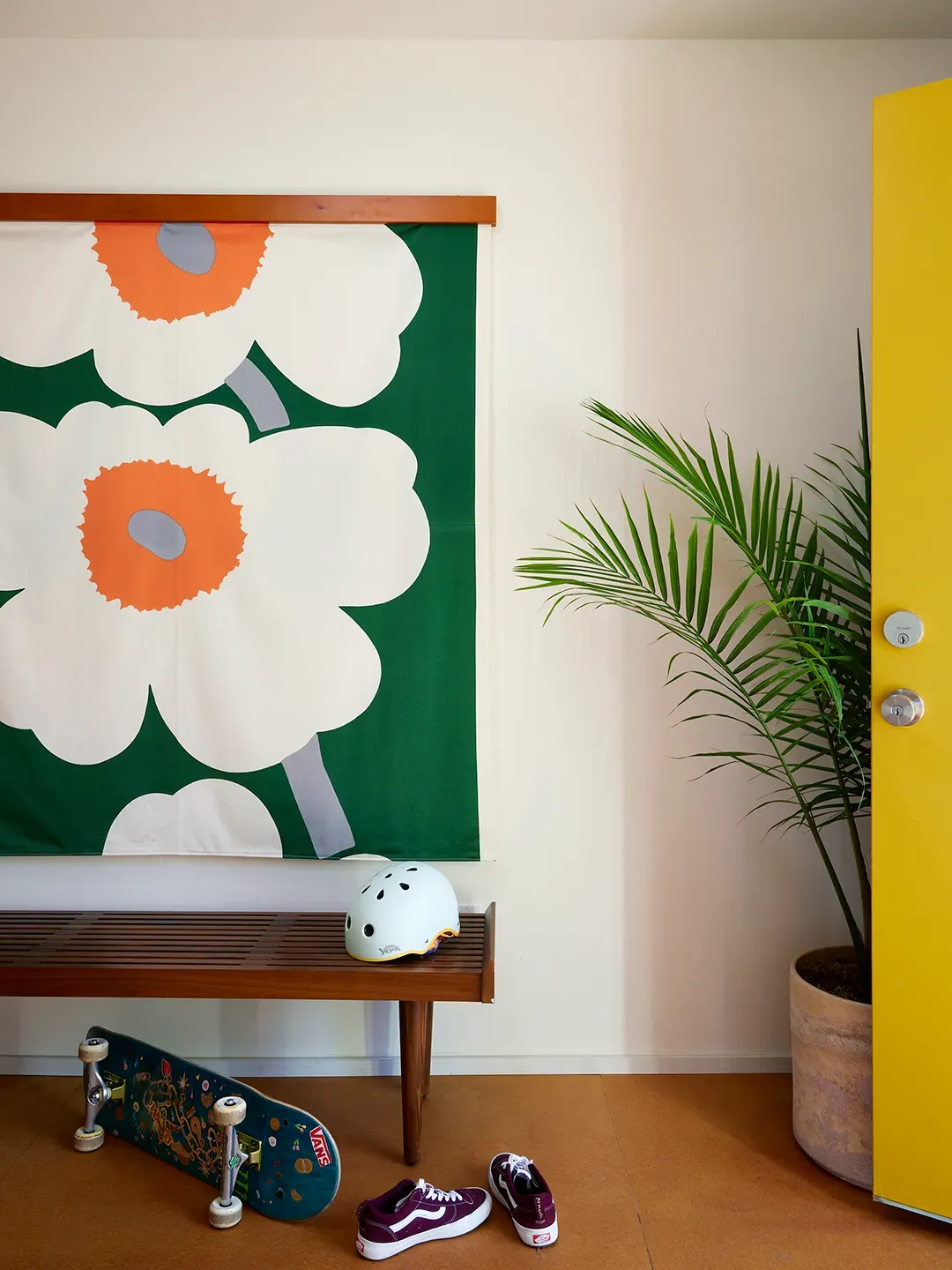 Entry hits hard — giant flower wall hanging, green backdrop. Cheerful, almost cartoon.