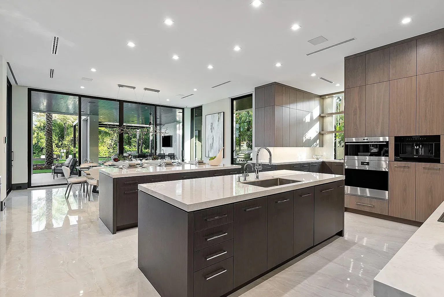 Here's the gourmet kitchen—wall of windows, greenery outside. Serious chef energy.