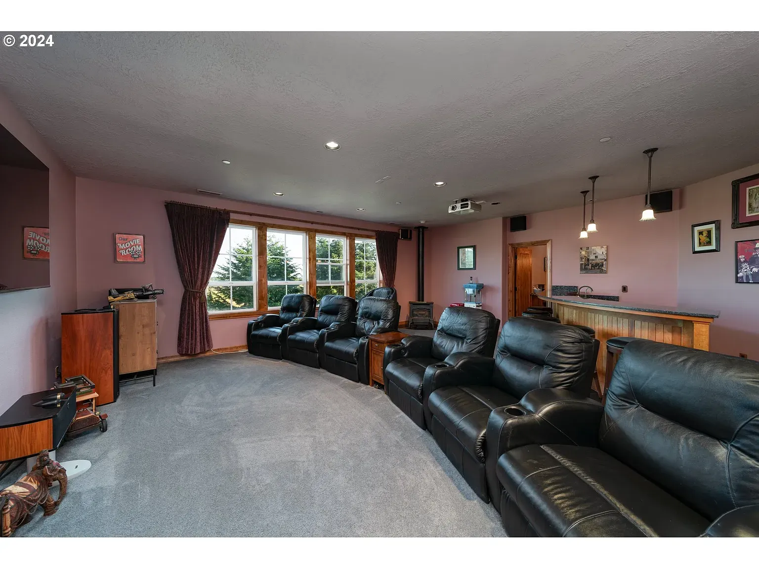 Home theater with blush walls and black recliners. Unexpected combo, kinda works.