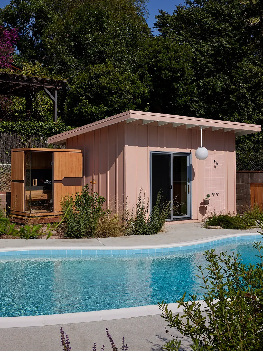 Here's the pink exterior — vertical siding, flat roof, big sliders from this angle.