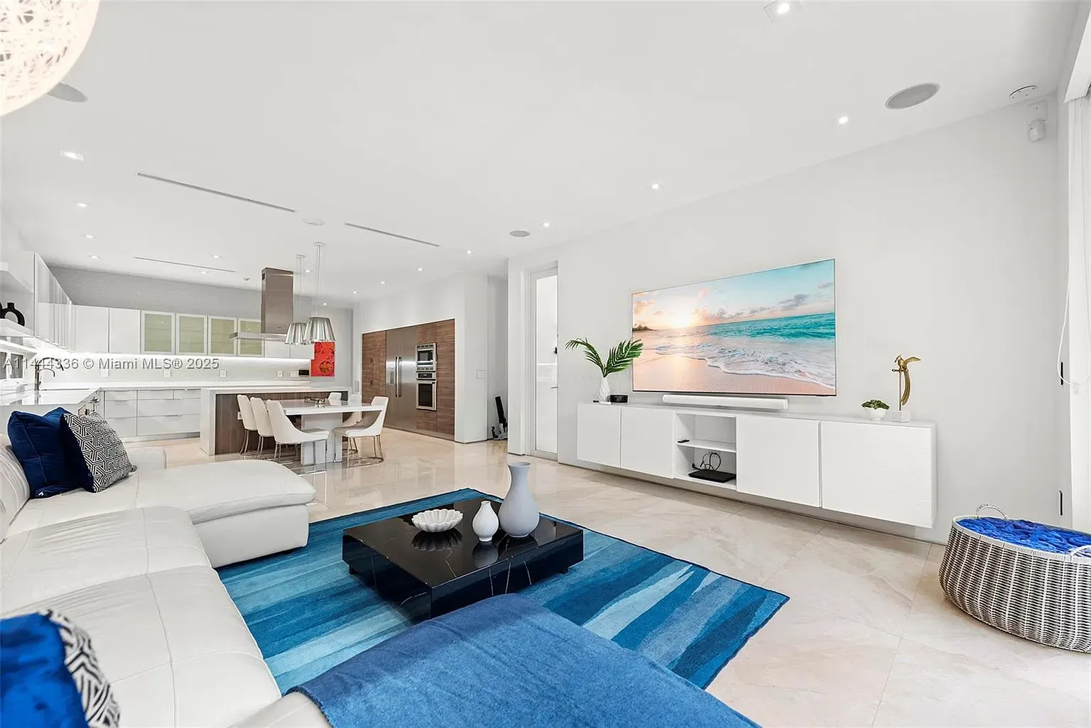 Soft cream sofa, blue pillows, deep rug. Calmer palette, I dig it.