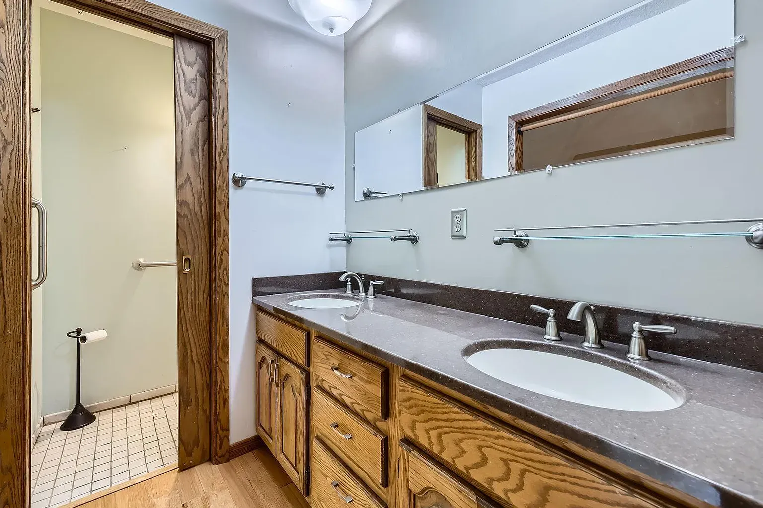Second bathroom goes classic—beige with dark wood. Those handles are ornate—why?