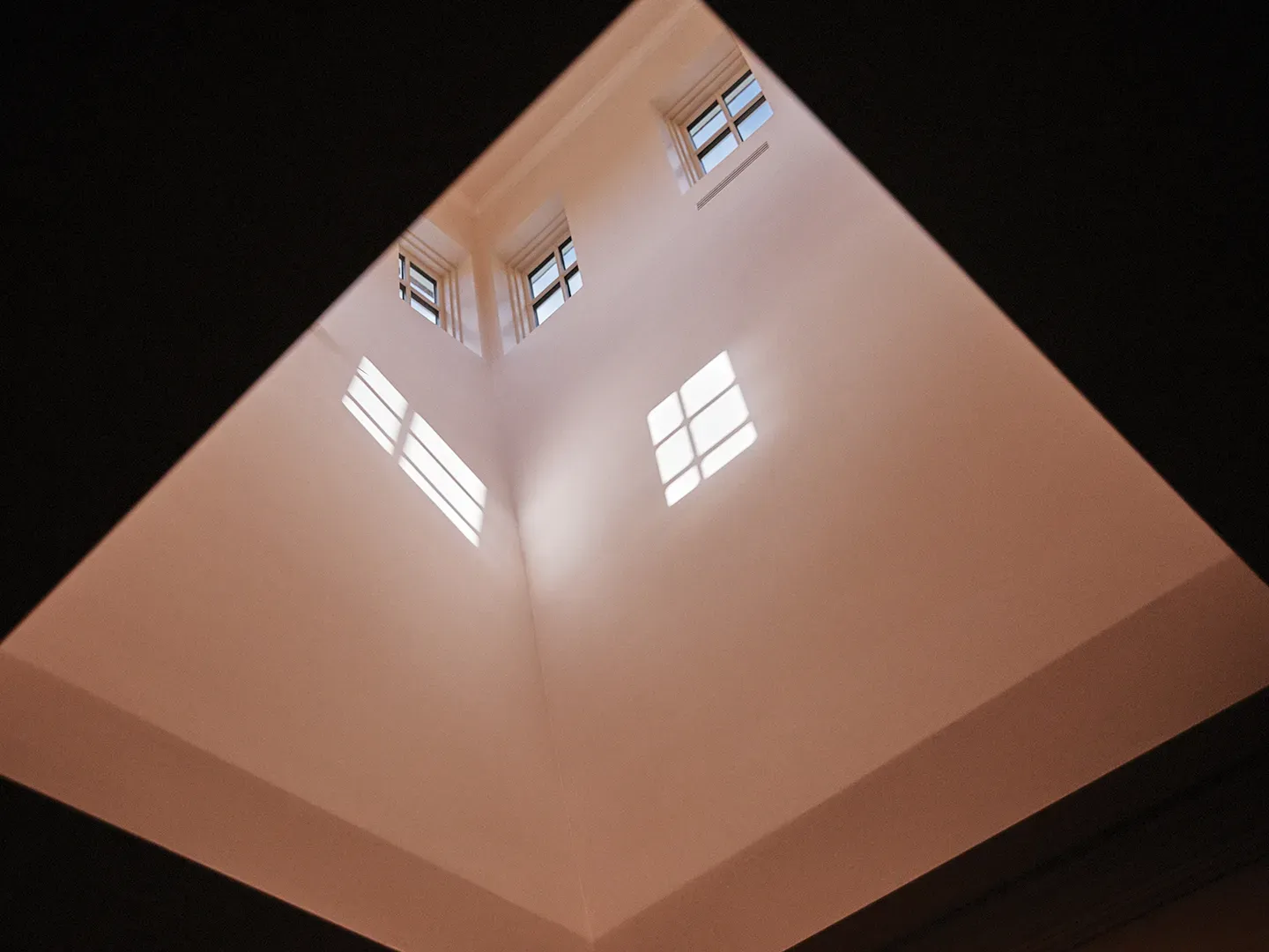 Skylight geometry is wild. Light pours down, cream walls catch everything.