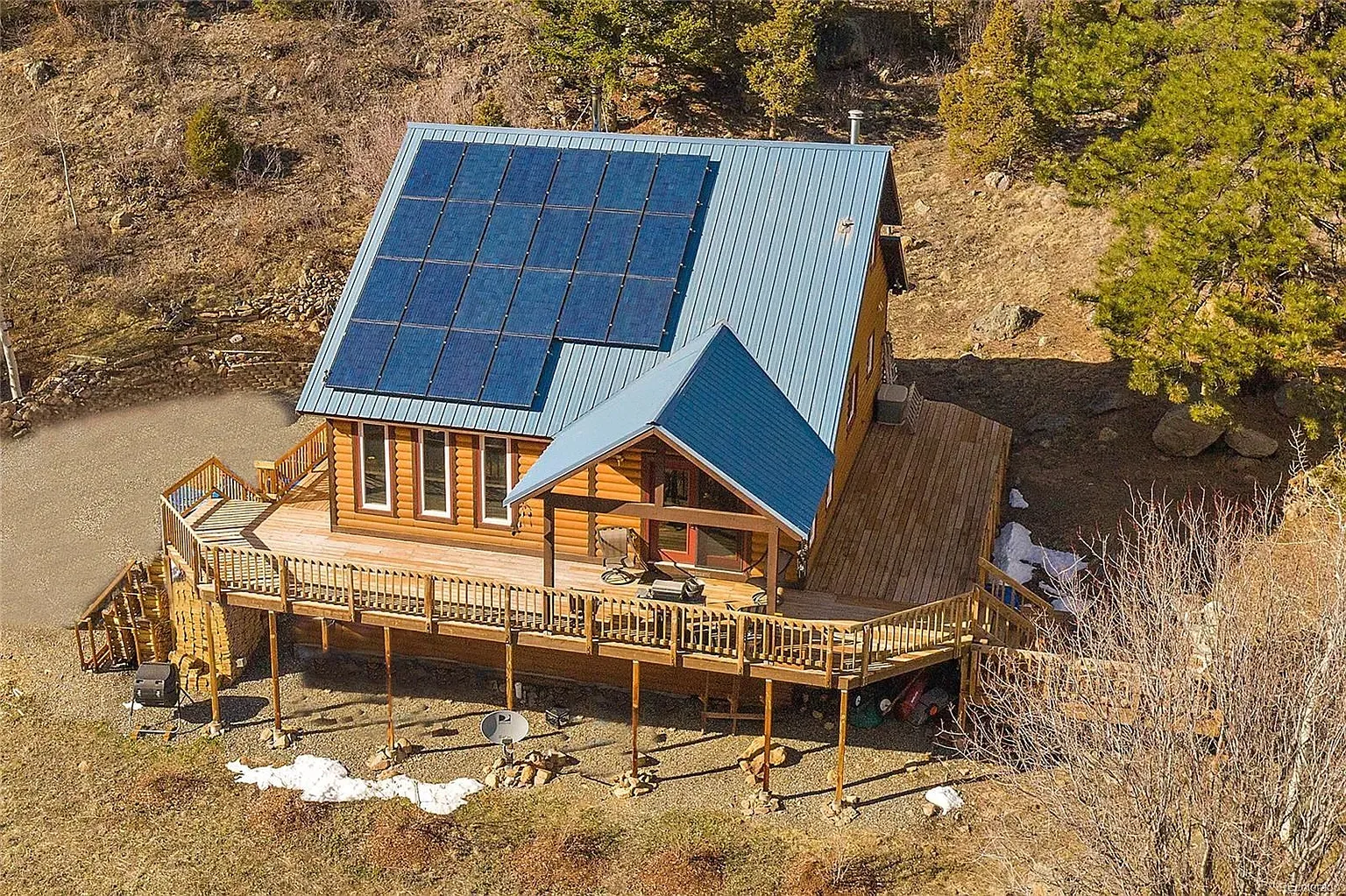 Here's the exterior—warm wood, blue roof, solar panels flexing. Kinda works.
