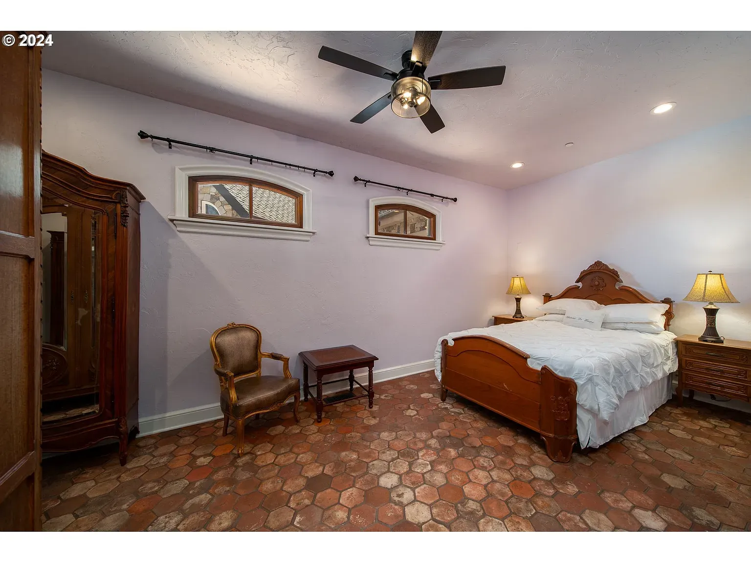 Another lavender bedroom—textured walls, mellow lamp glow. Calm without feeling sleepy.