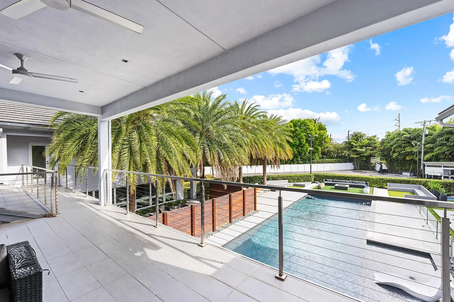 Big covered terrace, white tiles, glass railing. Breeze feels built in.
