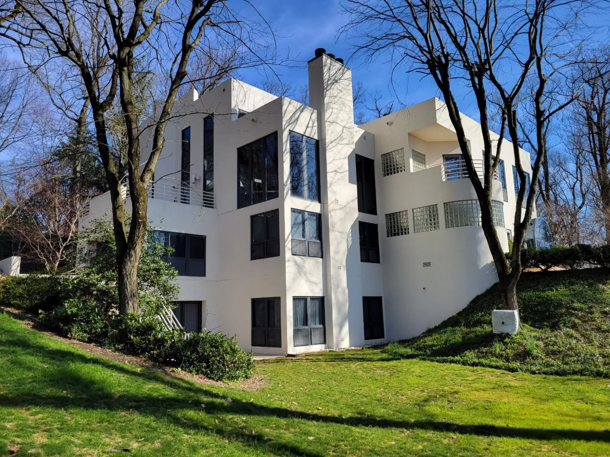 Back outside, sharp white box with huge windows. Dramatic, kinda gallery vibes.