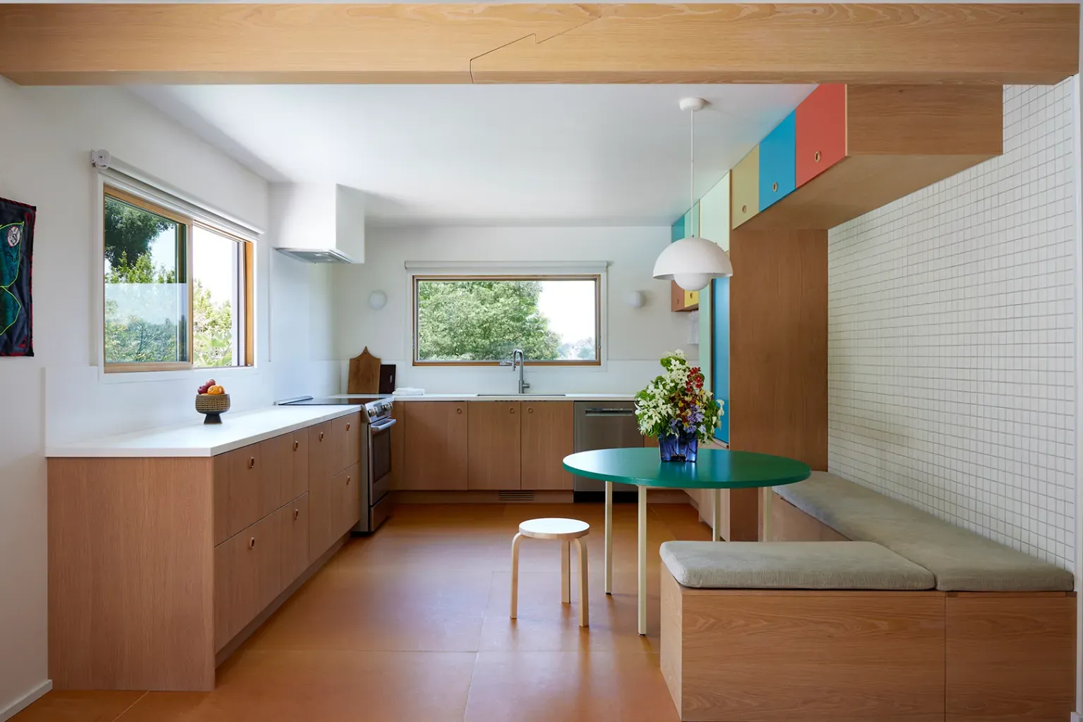 Second kitchen? From this angle, big window, warm wood, little color pops. Not mad.