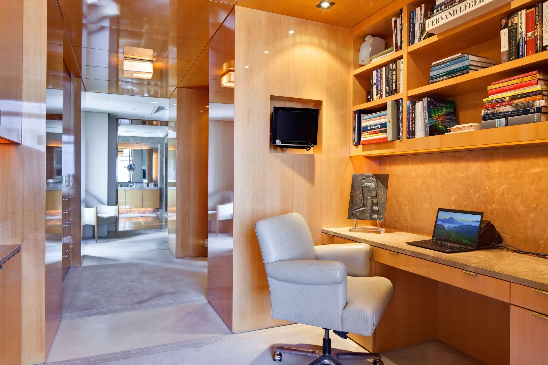 Warm wood panel office. Feels zen, but where do the cables go?