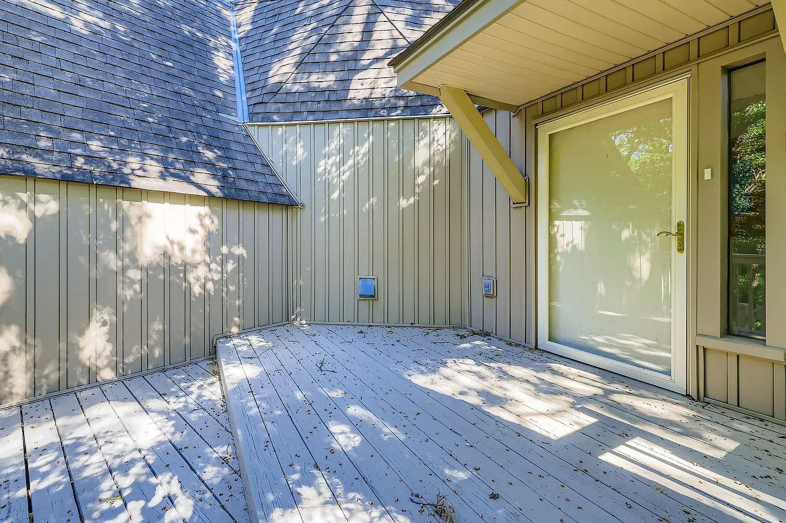 Partially enclosed patio with taupe wood panels. Angled roof, filtered sun. Yes please.