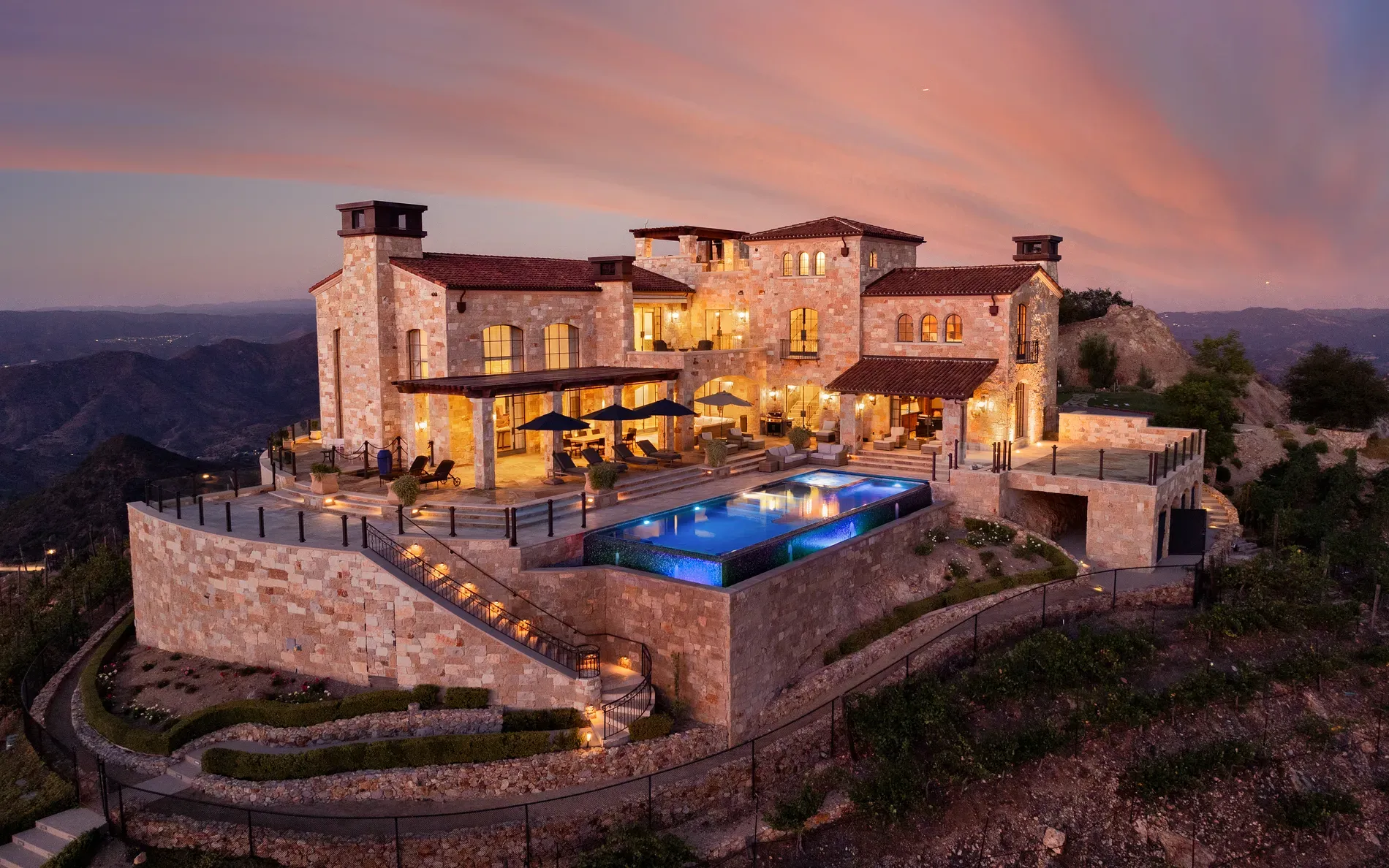 Here's the hillside villa—stone, warm stucco, terracotta roof, little turrets flexing.