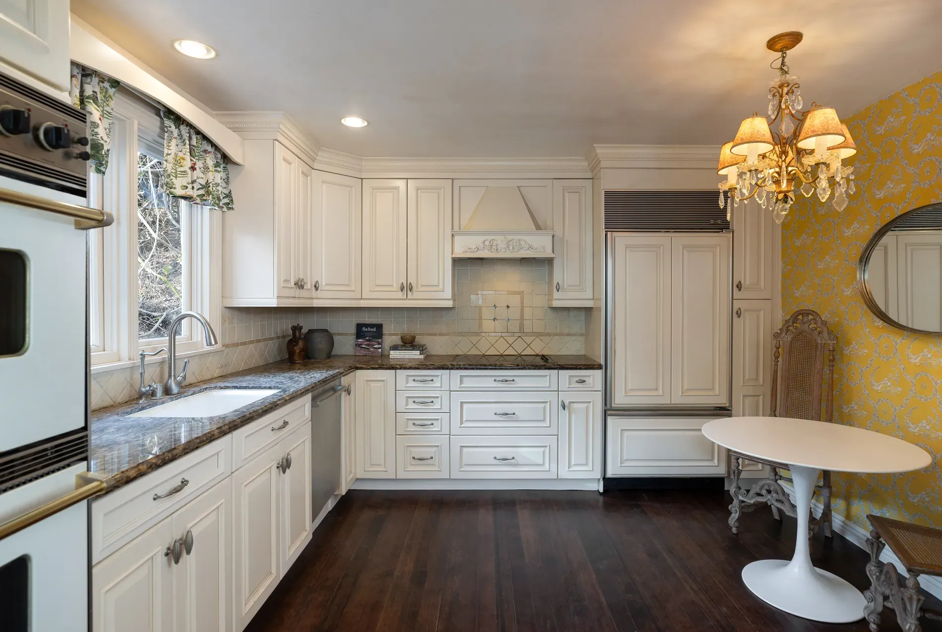 Here's the kitchen — white cabinets, vintage pulls, soft gray stone. Feels timeless.