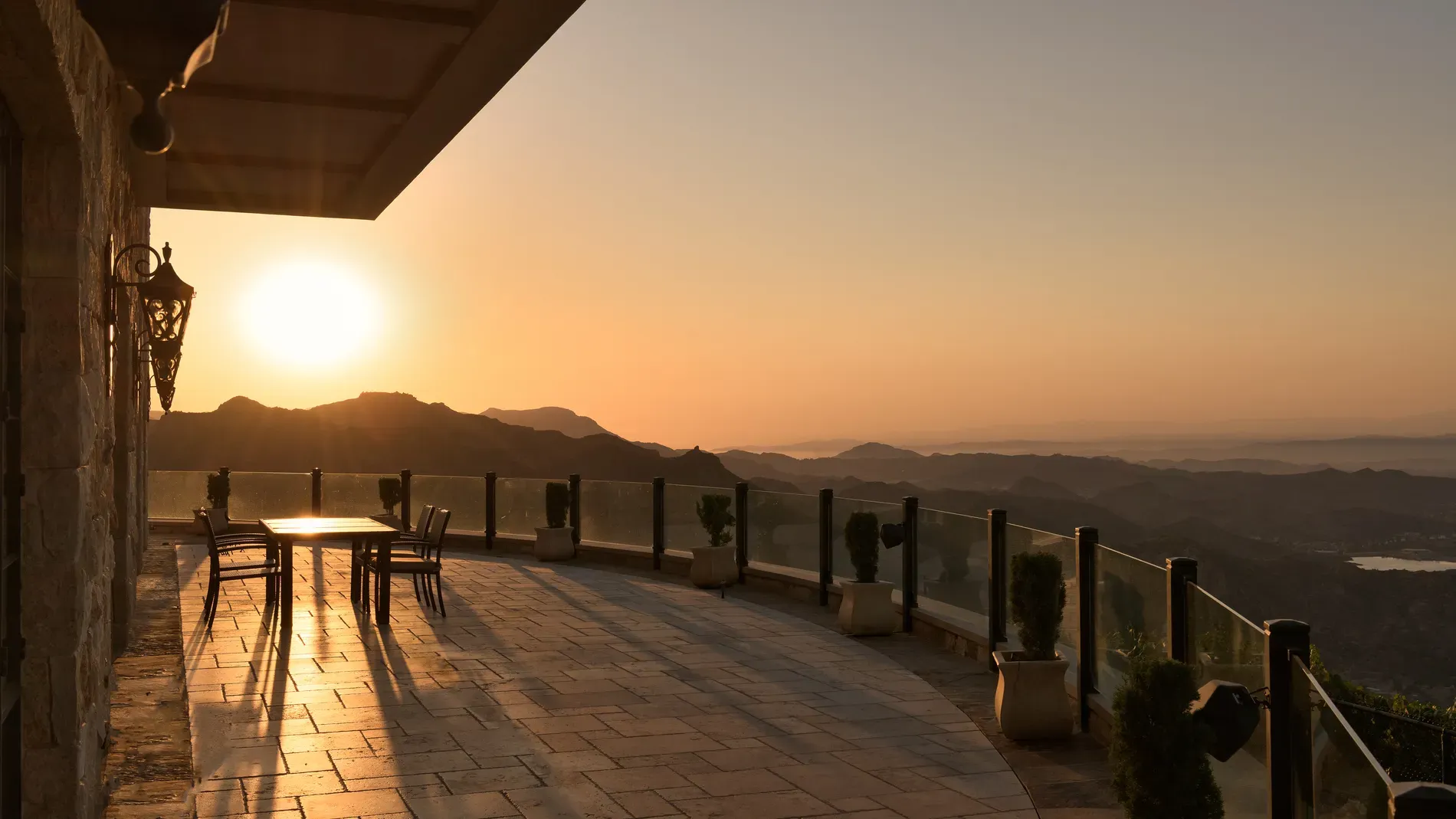Panorama terrace, beige stone underfoot. From this angle, mountains feel endless.