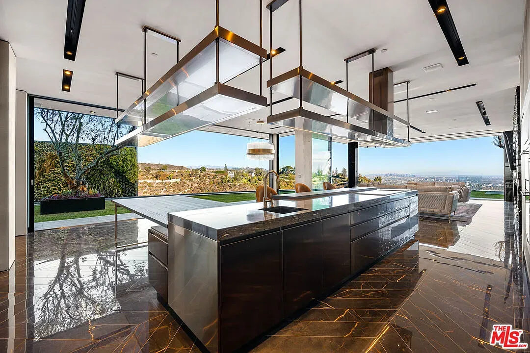 Here's the kitchen—chunky dark island, statement lights. Looks serious about snacks.