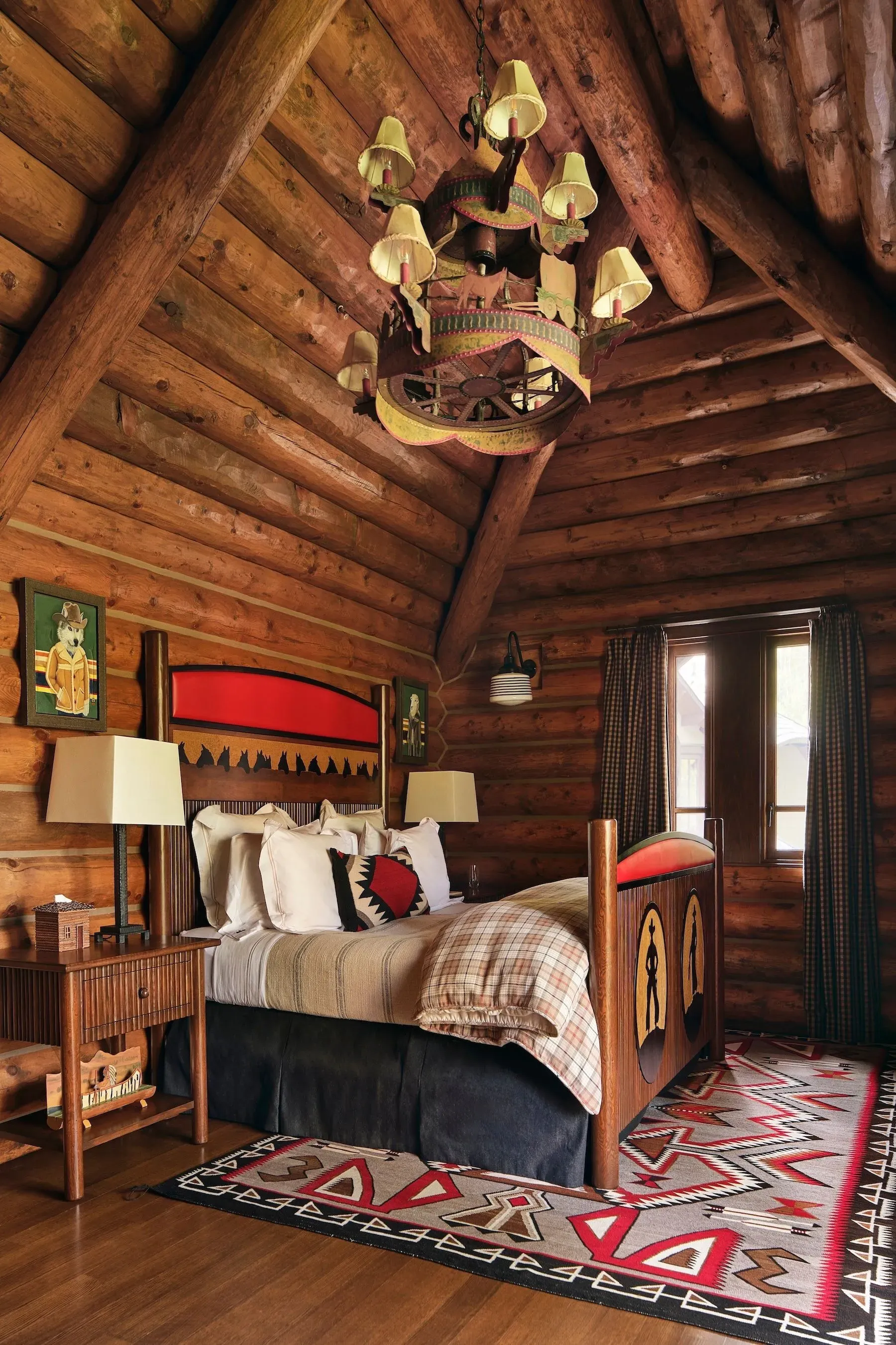 Bedroom goes cabin-core. Log walls, beams, red headboard. Comfy, maybe a tad busy.