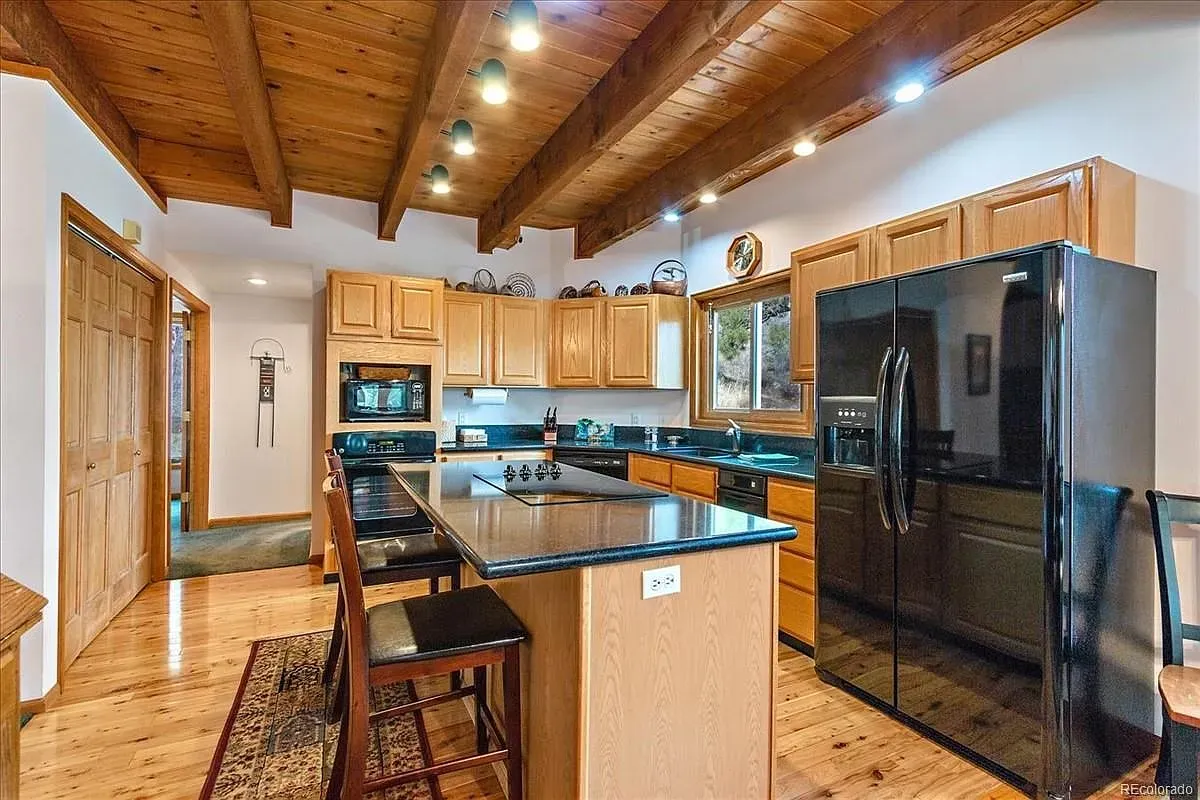 Here's the kitchen—beams, honey cabinets, black counters. I mean, it works.