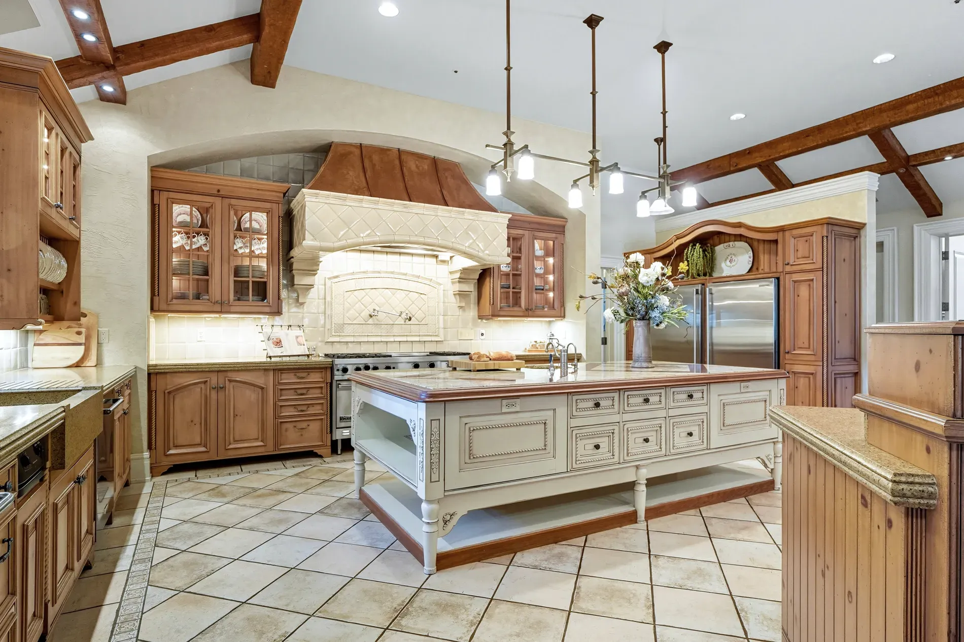 Kitchen island is creamy glam against warm wood. Not sure about the feet.