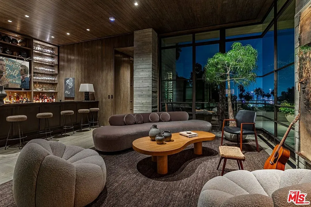 Lounge vibes. wood ceiling, soft neutrals, plush shapes. Looks quietly expensive.