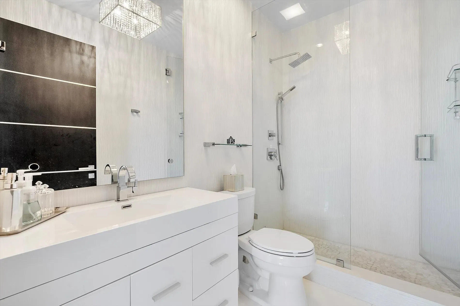 Another bath, more white with dark accents. Nice contrast. Storage hiding somewhere?