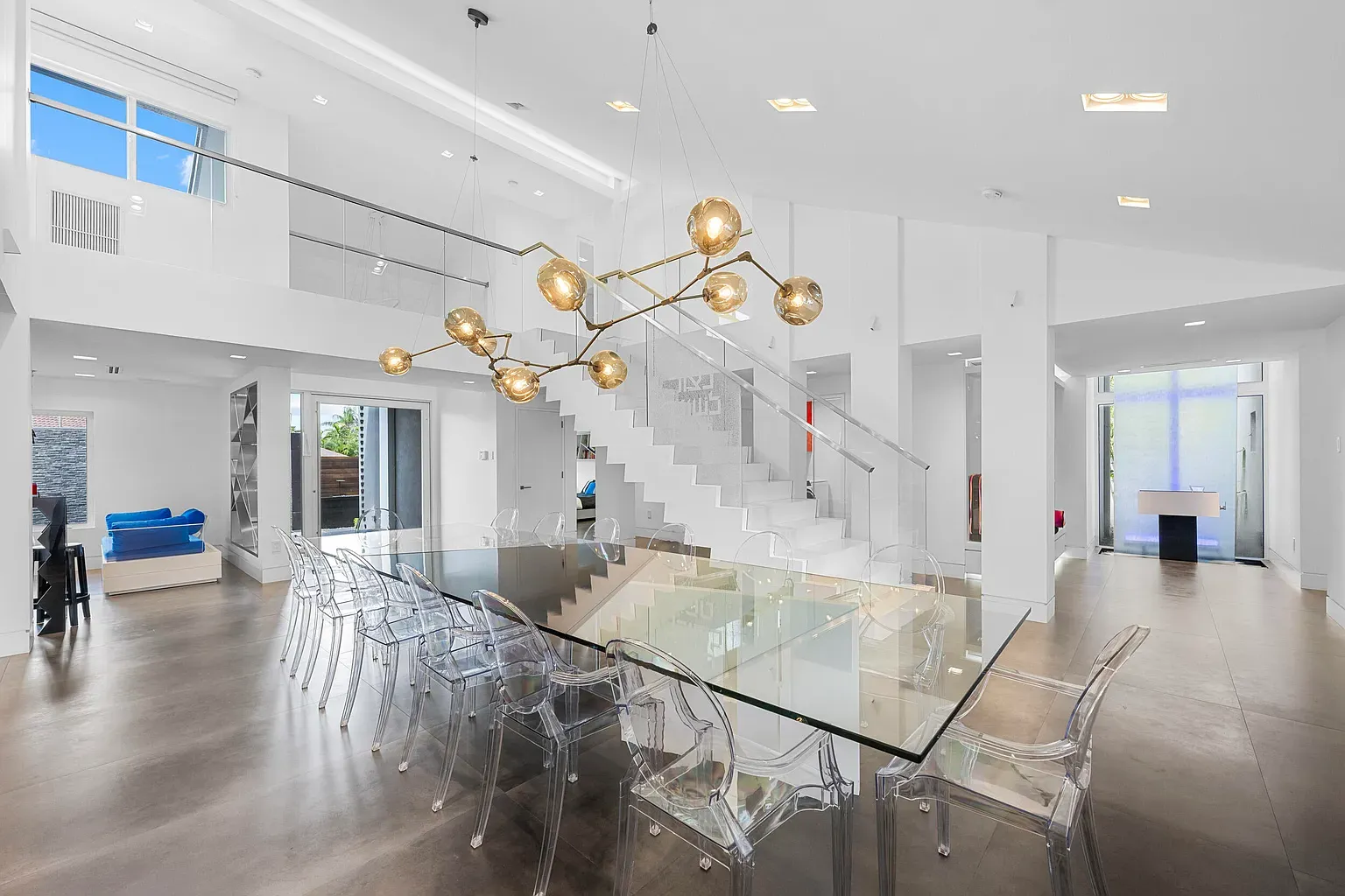 Glass table with ghost chairs on concrete. Not sure about this combo.