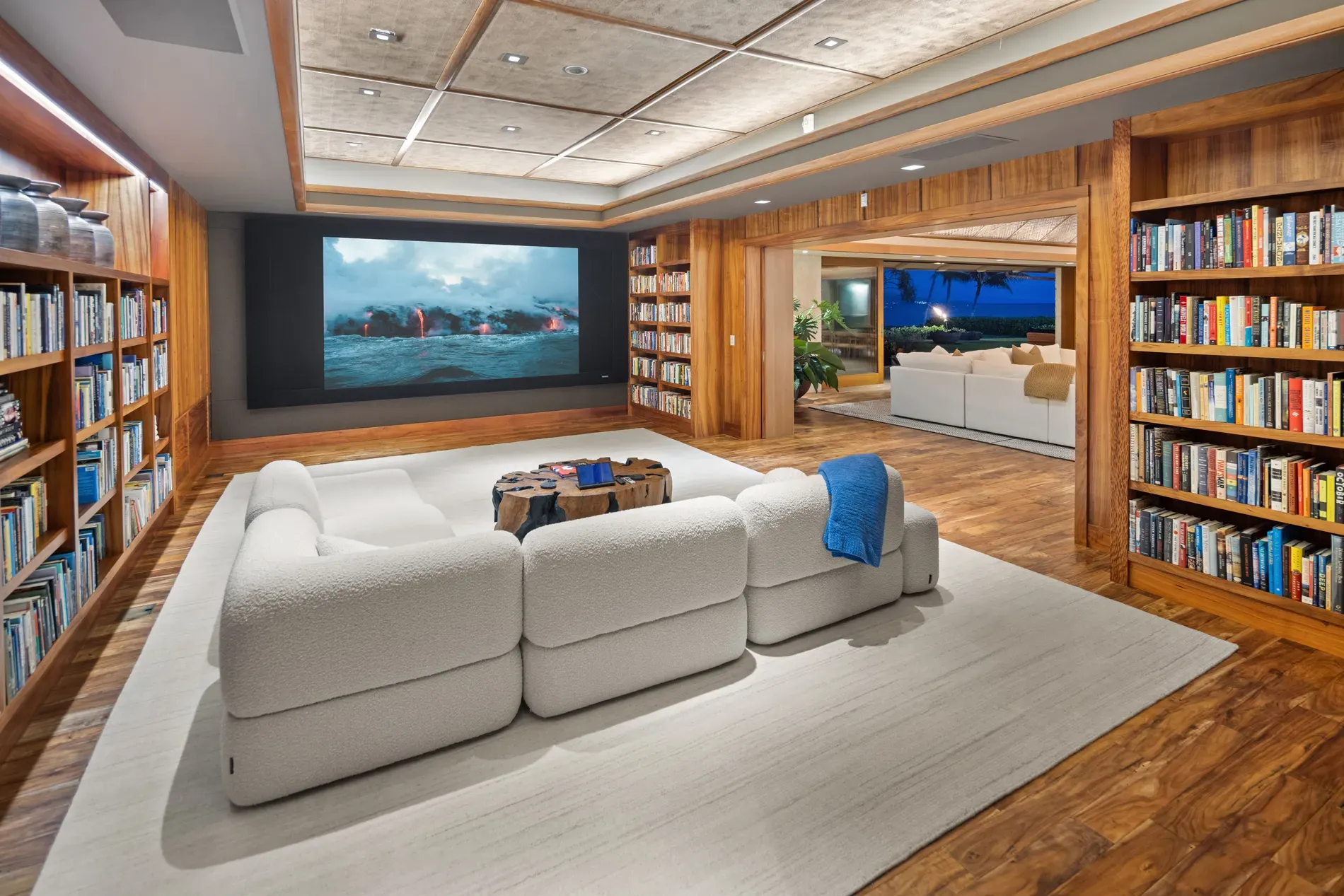 And then this cozy lounge — wood everywhere, huge rug, sink-in sofa situation.