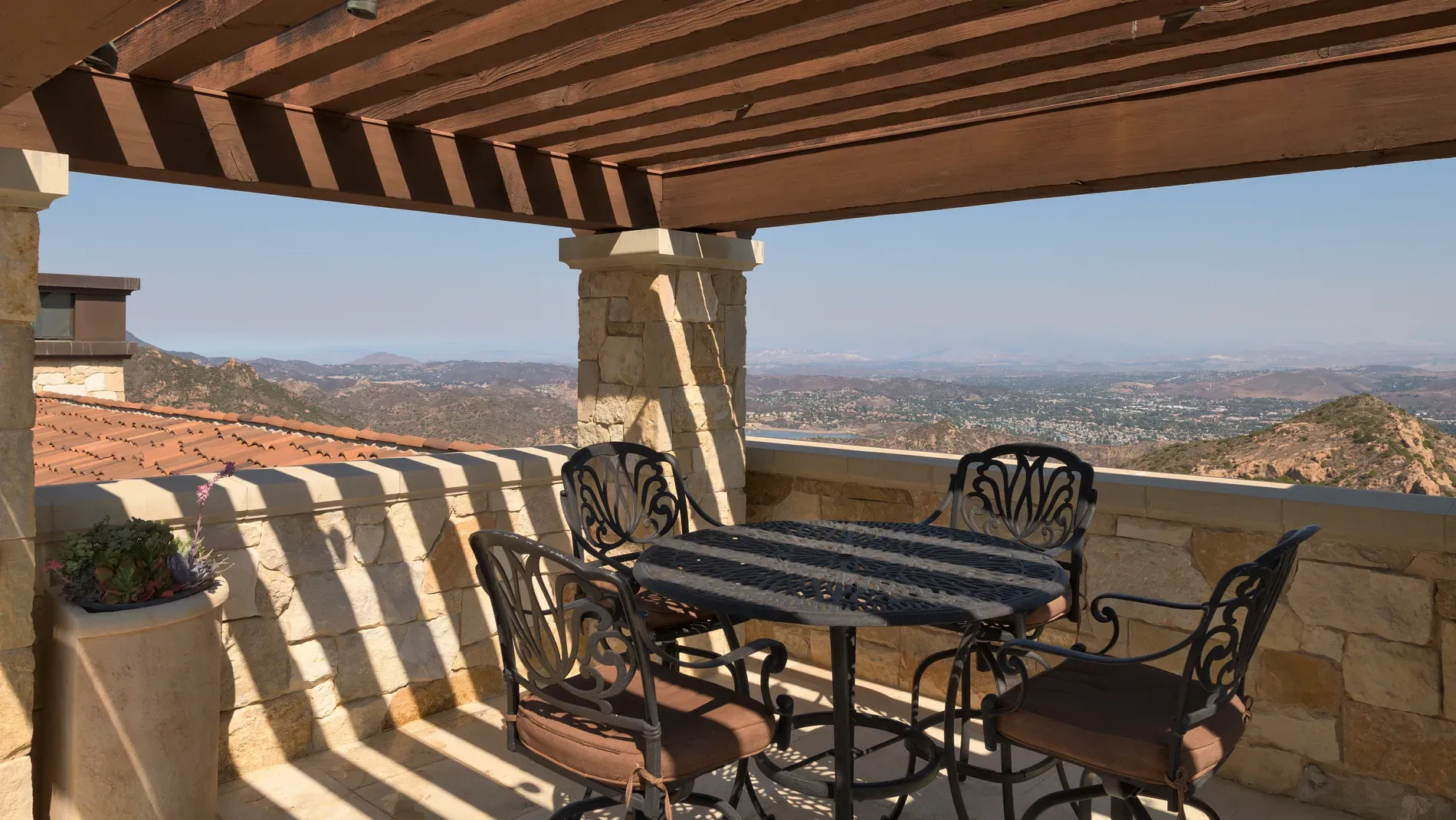 Pergola on stone columns—shade goals. Does the lattice block stargazing though?